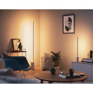 Philips Hue Signe LED Tischleuchte aus Aluminium in einem Wohnraum mit warmem Licht.
