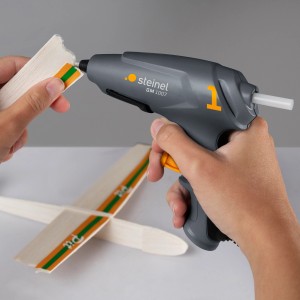 Steinel GlueMatic 1007 Heißklebepistole mit Klebesticks beim Basteln eines Holzflugzeugs.