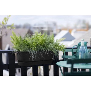 Schwarzer Elho Greenville Easy Balcony Hängetopf (52cm) mit Bepflanzung am Balkongeländer.