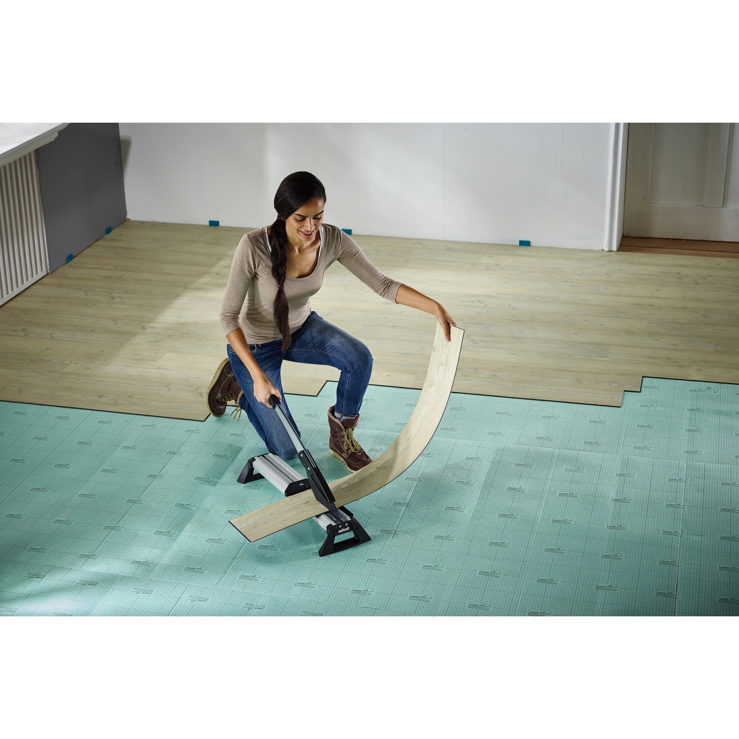 Frau schneidet Laminat mit wolfcraft Vinyl- und Laminatschneider VLC 800. Werkzeug zum Laminat verlegen.