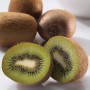 Frische Kiwis, ganze und halbiert, vor einer weißen Schale. GROW by OBI Kiwi.