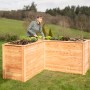 Westmann Holz-Eckhochbeet Klassik L, naturbelassen, mit Frau beim Bepflanzen im Garten.