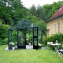 Juliana Gewächshaus Premium 13 Anthrazit im Garten mit geöffneter Tür und Pflanzen.