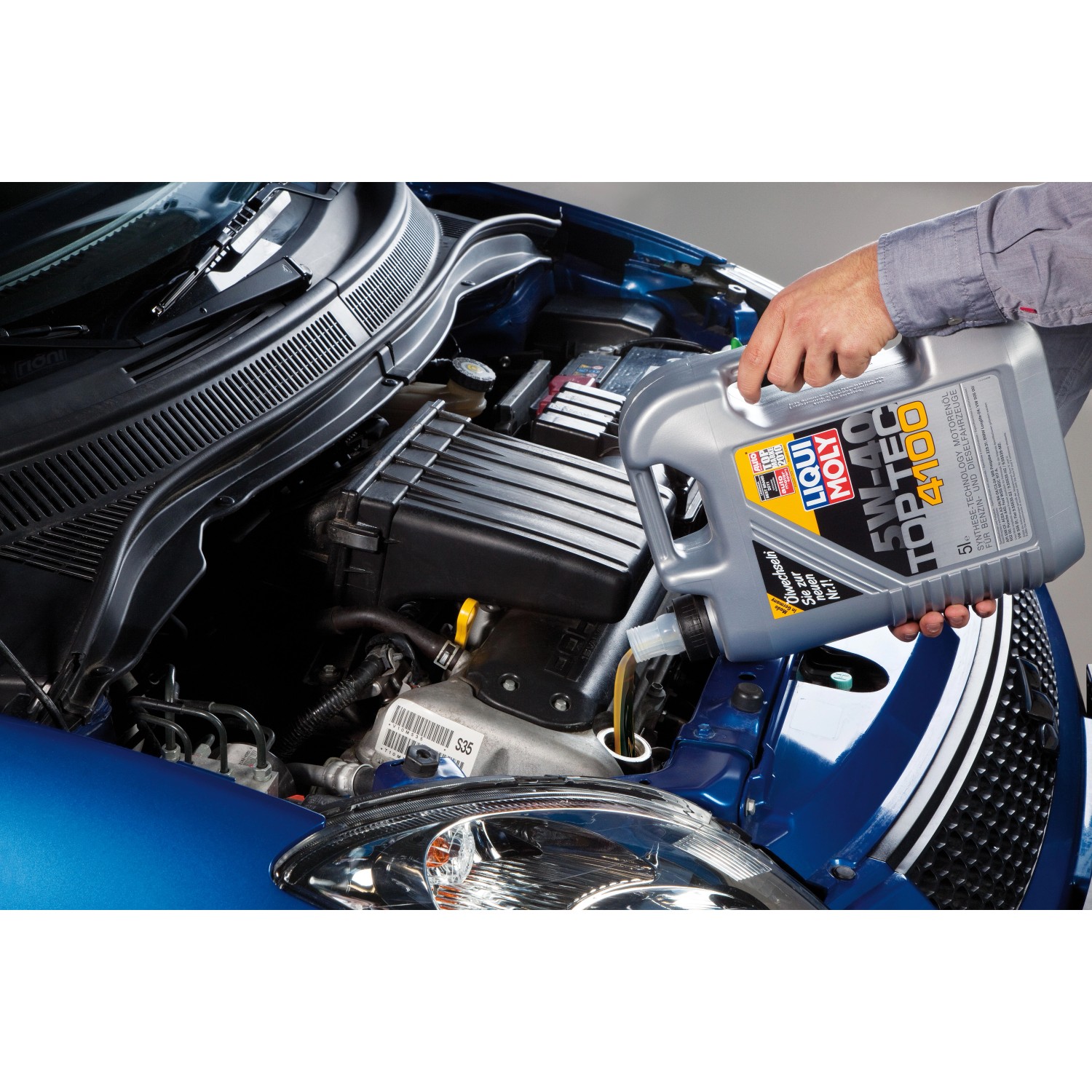 Liqui Moly Top Tec 4100 5W-40 Öl wird in einen blauen Automotor eingefüllt.
