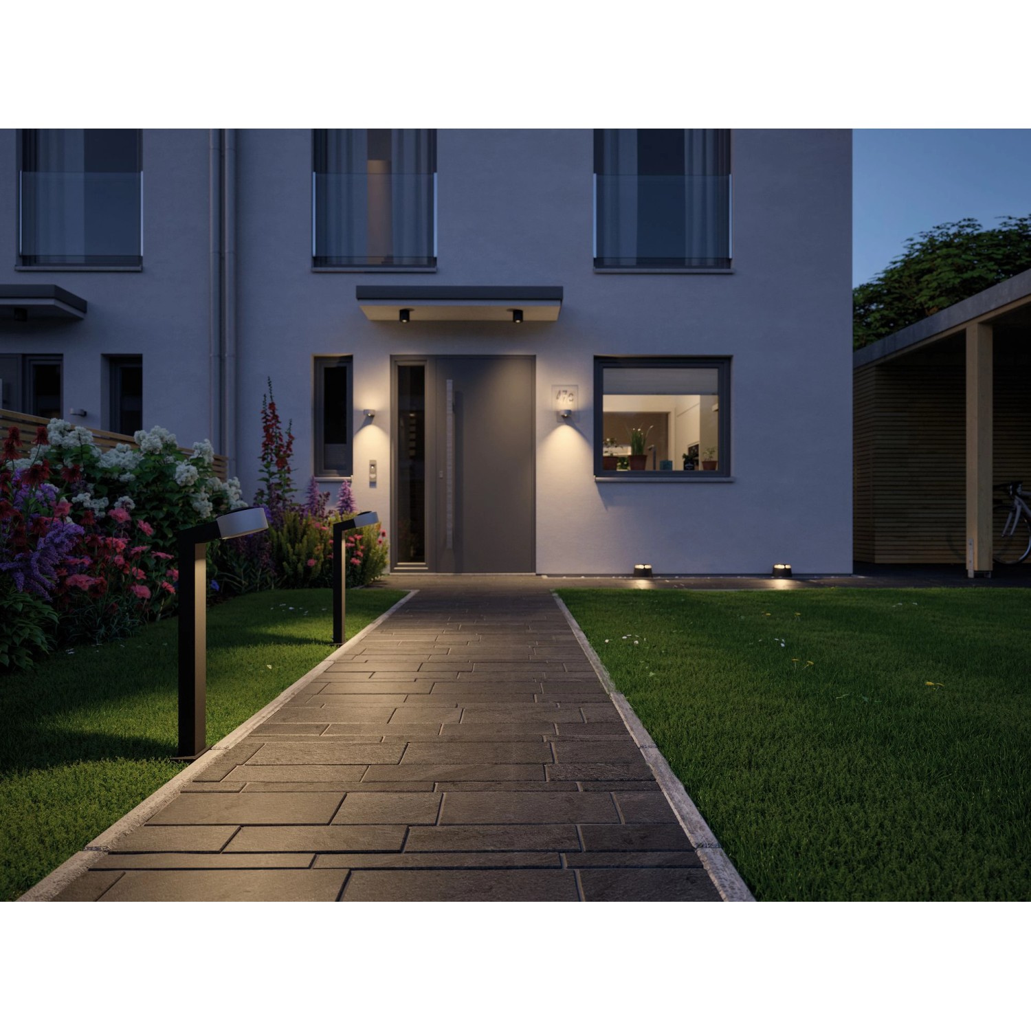 Paulmann Plug & Shine LED-Bodenleuchten beleuchten einen Gartenweg mit warmweißem Licht.