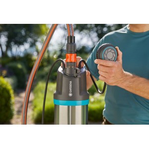 Gardena Tauch-Druckpumpe 5900/4 inox mit Schlauch und Bedienelement in der Hand.