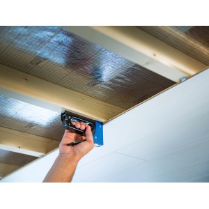 LUX Handtacker Comfort beim Befestigen von Isolierung an einer Decke.