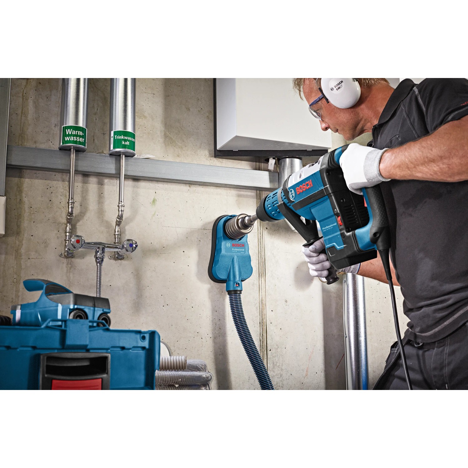 Bosch Professional GDE 68 Staubabsaugung im Einsatz mit Bohrmaschine an Wand.