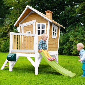 Axi Robin Spielhaus mit Rutsche: Braun-weißes Holzhaus mit lindgrüner Rutsche und zwei Kindern im Garten.