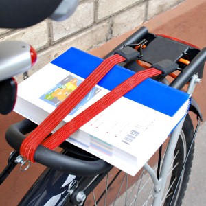 Rotes Master Lock Gummi-Spannseil zur Befestigung von Büchern auf einem Fahrradträger.