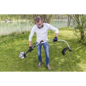 Mann montiert Al-Ko Benzinmotorsense BC 223 L-S im Garten. Leichte Motorsense für flexibles Arbeiten.
