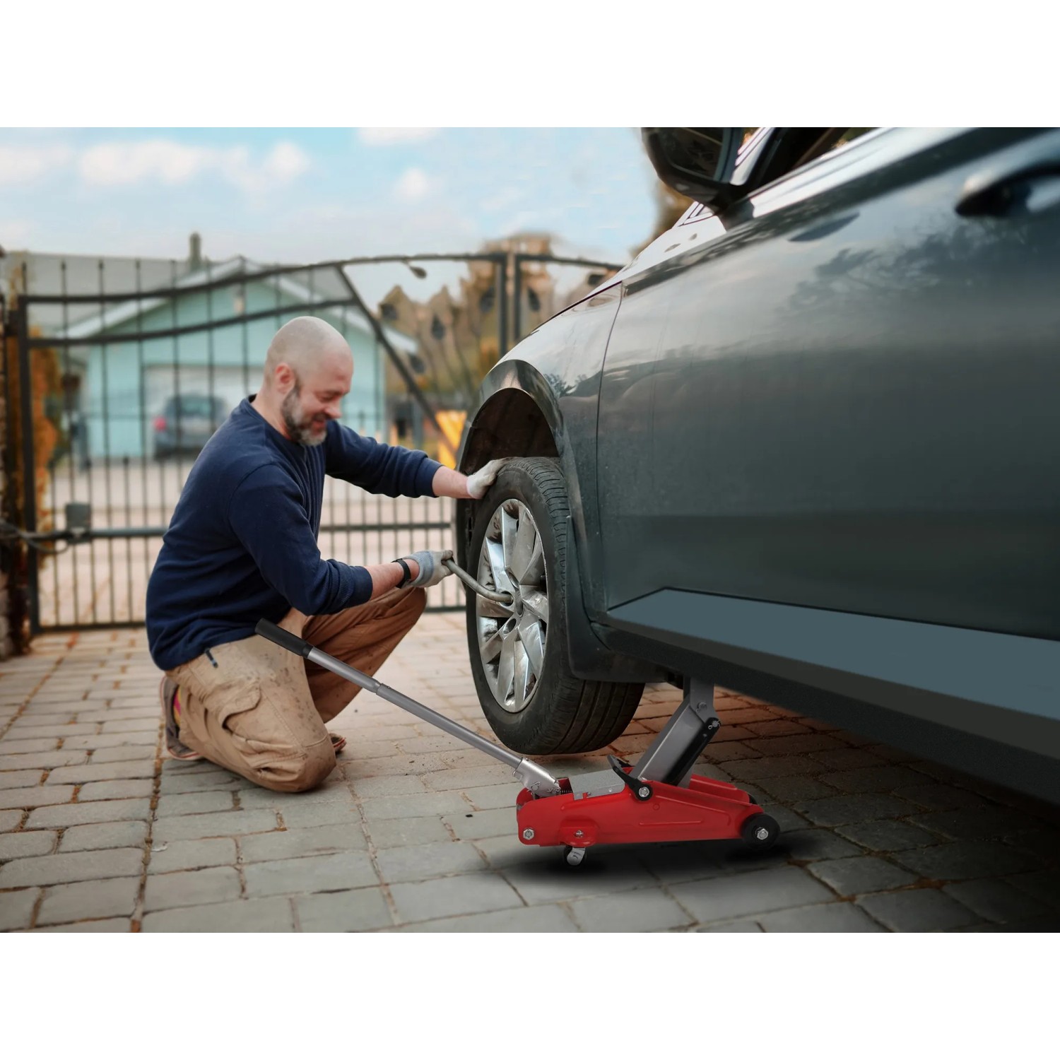 Mann wechselt Reifen mit rotem Apa Rangierwagenheber 2.000 kg am Auto.