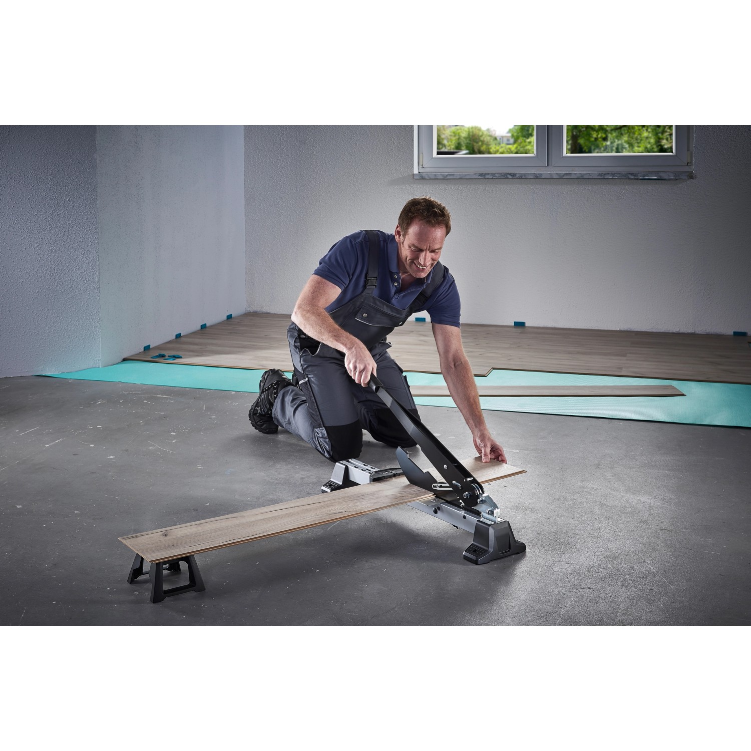 Mann schneidet Laminat mit dem wolfcraft Vinyl- und Laminatschneider VLC 1000. Werkzeug für Laminat & Parkett.