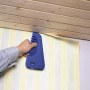 LUX Clipstrip Andrückspachtel in Anwendung zum Glattstreichen von Tapete.