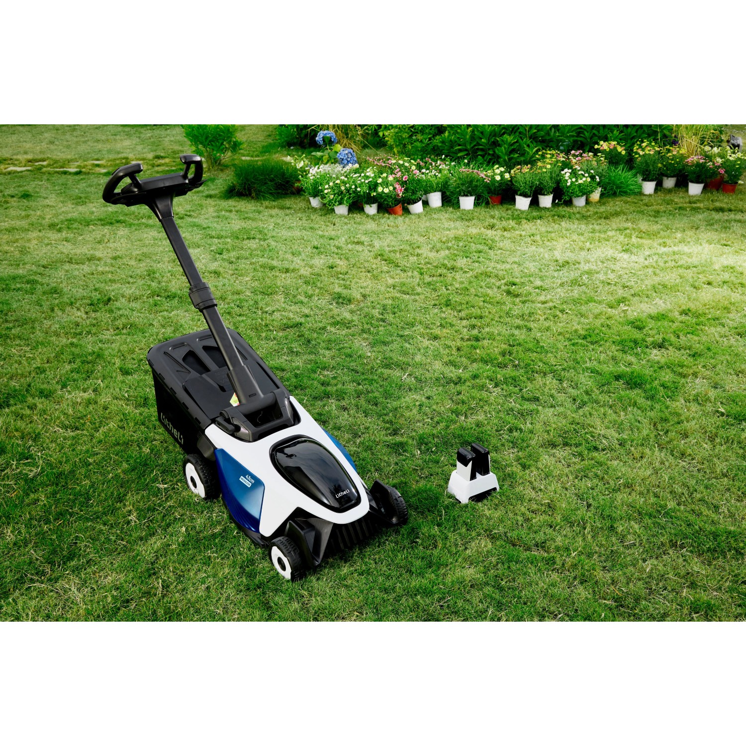 Litheli Akku-Rasenmäher EasySurge mit Akkus und Mulchkeil auf Rasenfläche.