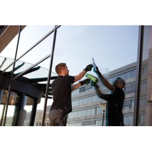 Mann reinigt Fenster mit Unger Fenstereinwascher MicroStrip 45 cm (grün).