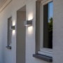 Weiße LUTEC LED-Außenwandleuchte Gemini an einer Hauswand.
