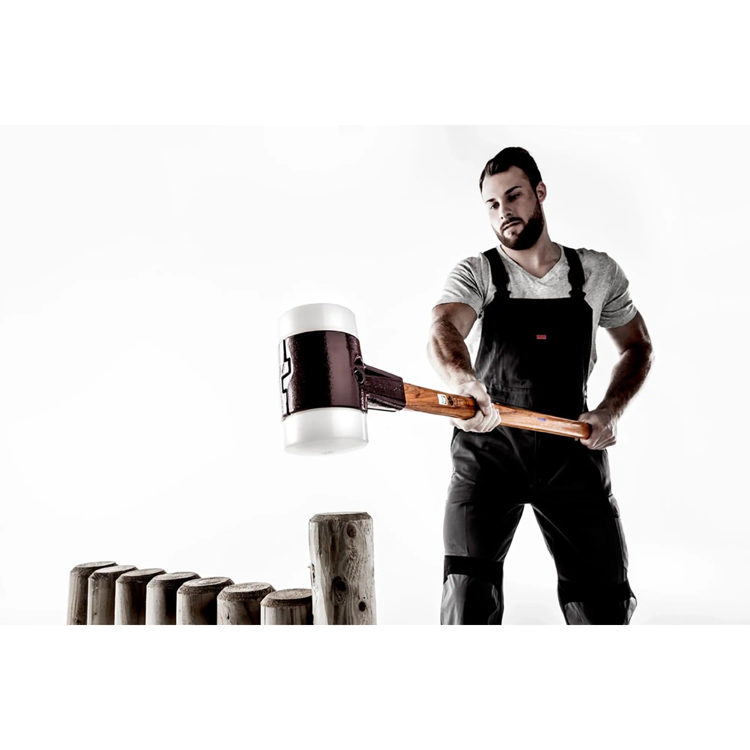 Mann mit Halder Vorschlaghammer (D 100 mm) mit Gummi- und Superplastik-Einsatz beim Einschlagen von Holzpfosten.