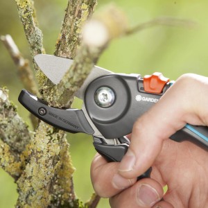 Gardena Gartenschere A/M beim Schneiden eines Astes. Amboss-Schere mit Antihaftbeschichtung.