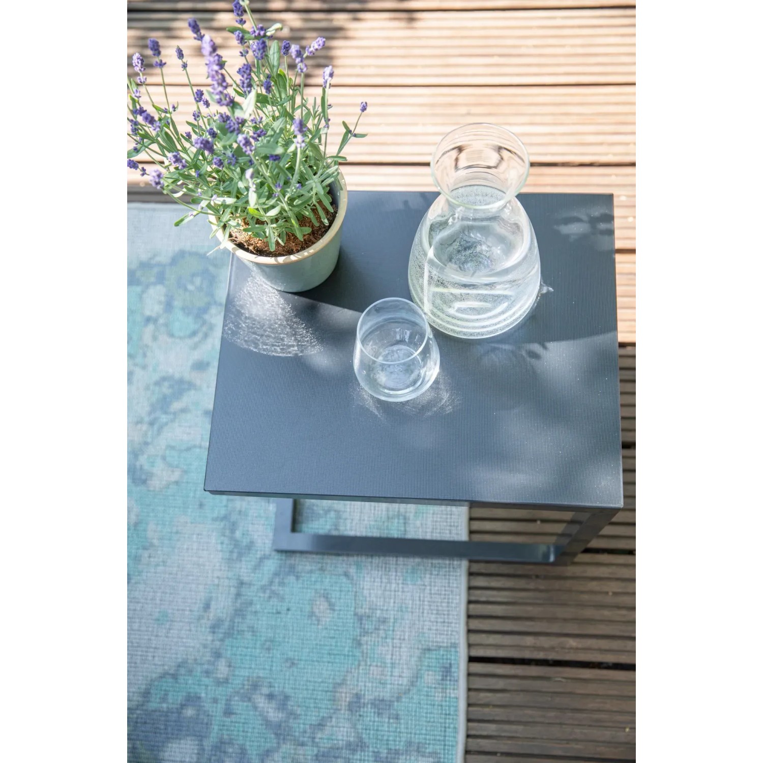 Rechteckiger, anthrazitfarbener Siena Garden Gartentisch Ramo mit Pflanze und Getränken.
