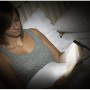 Frau liest im Bett mit Energizer Booklight Speziallampe, einer LED-Taschenlampe mit Klemme.