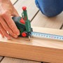 Bosch Maßband mit Tieflochmarker beim Anzeichnen eines Holzbretts. Teil des Werkzeugkoffers.