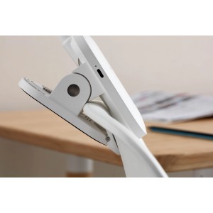 Weiße Philips LED-Tischleuchte Forys mit Clip-Halterung am Tisch befestigt.