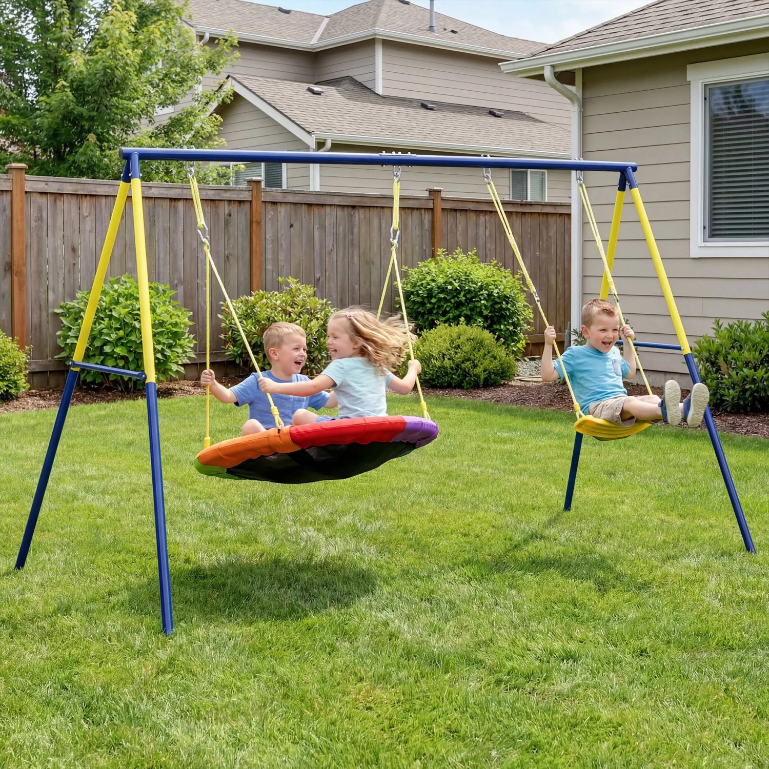 Kinder spielen auf blau-gelbem AIYAPLAY Stahl Schaukelgestell mit Nest- und Einzelschaukel im Garten.