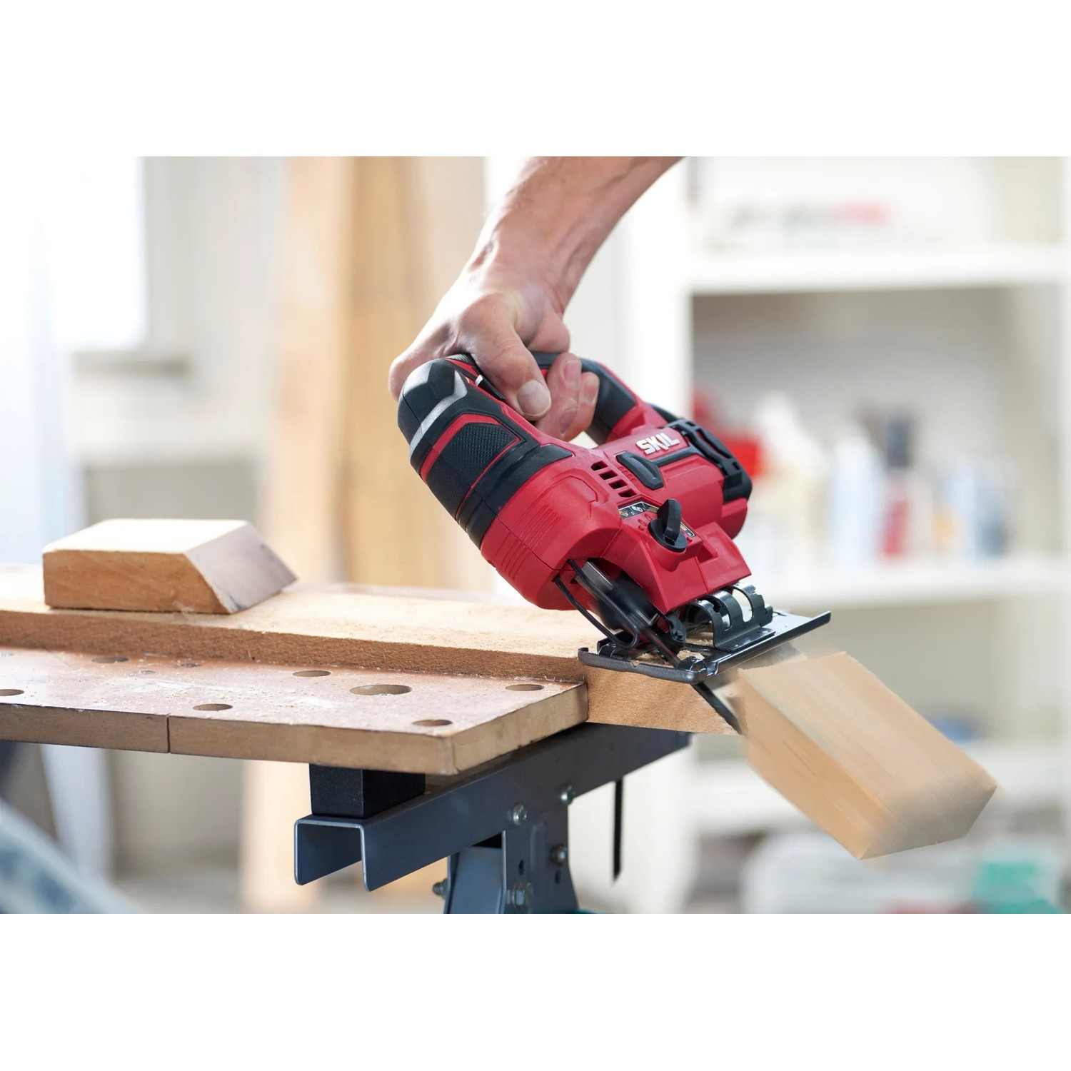 Skil Stichsäge 4530AA in Rot beim Sägen von Holz auf einer Werkbank.
