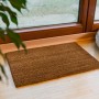Astra Fußmatte Coco Eco, 40x60 cm, aus Kokosfaser, vor einer Tür auf hellem Holzboden.