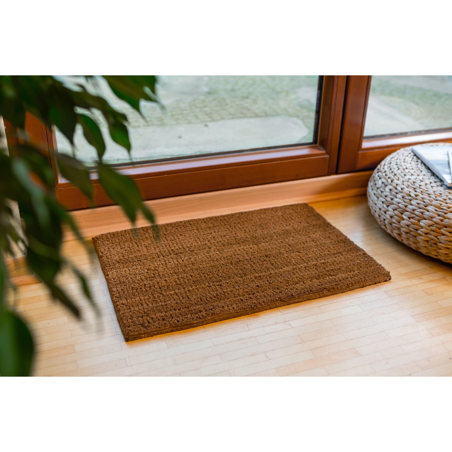 Astra Fußmatte Coco Eco, 40x60 cm, aus Kokosfaser, vor einer Tür auf hellem Holzboden.