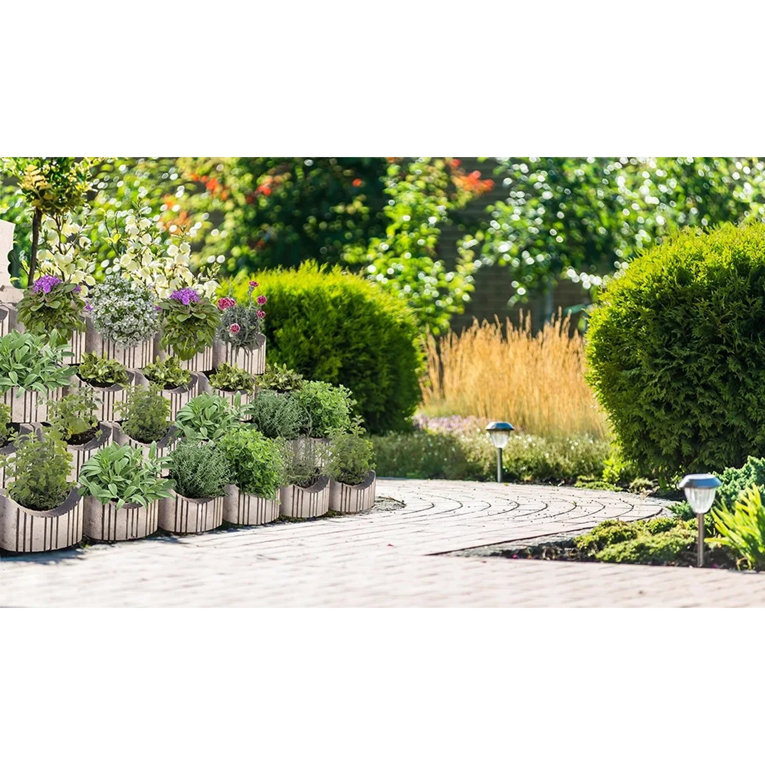 Begrünte Böschung mit grauen Pino Böschungssteinen (11,5x26x26 cm) im Garten.