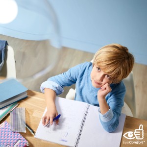 Junge lernt am Schreibtisch unter einer Philips E27 LED Lampe mit EyeComfort.