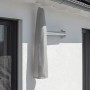 Eingepackter, anthrazitfarbener Schneider Ampelschirm Muro Ø 250 cm mit Schutzhülle an Hauswand.