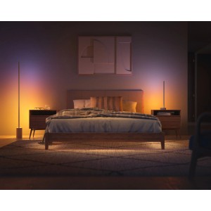 Schlafzimmer mit Philips Hue Gradient Signe Oak Tischleuchte, die farbiges Licht ausstrahlt.