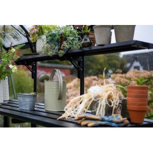 Halls Lamellenregal, klappbar, schwarz, mit Pflanzen und Gartenzubehör im Gewächshaus.