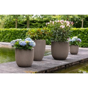 Capi Europe Blumentöpfe Kugel Groove NL, Ø 54 cm, Taupe, mit Pflanzen im Garten.