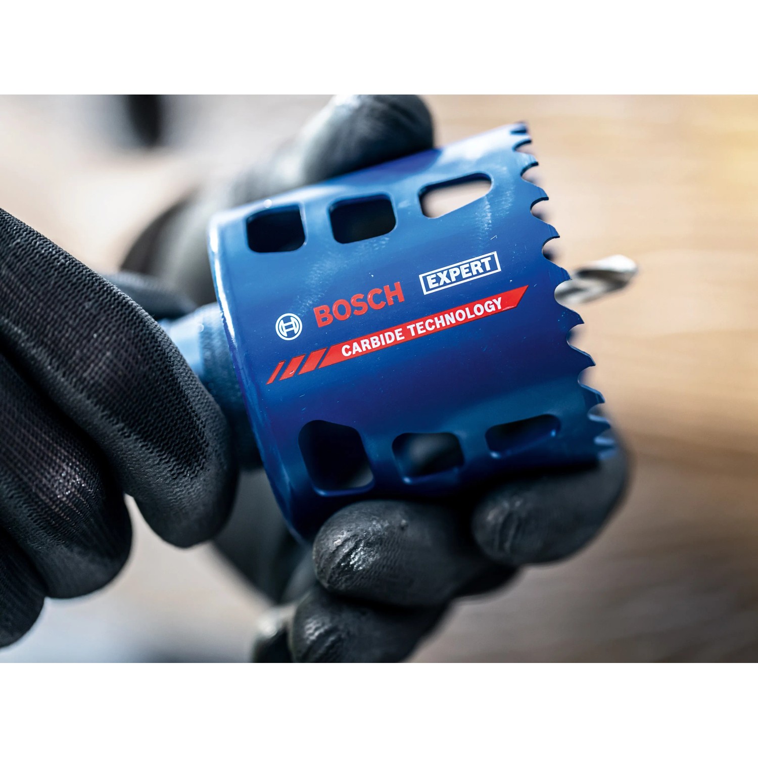 Bosch Expert Lochsäge Tough Material, Ø 68mm, in Händen mit Arbeitshandschuhen.