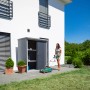 Trimetals Geräteschuppen Guardian D63 mit Boden, genutzt im Garten mit Rasenmäher.