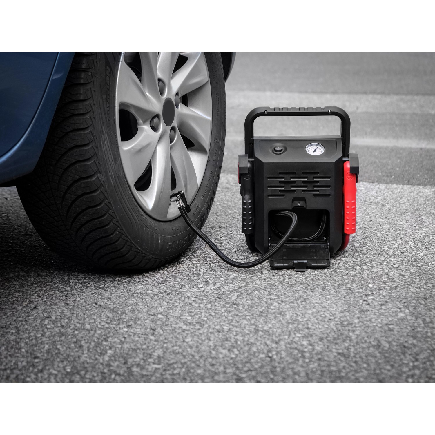 APA Starthilfe Powerpack mit Kompressor beim Aufpumpen eines Autoreifens.