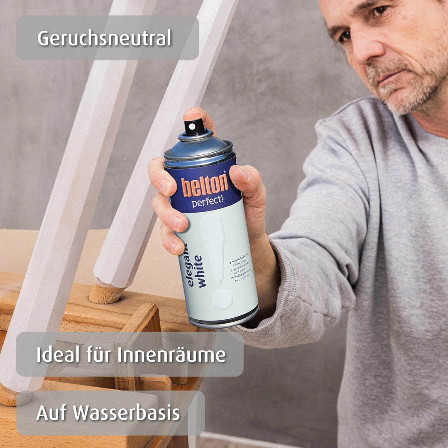 Mann sprüht belton Buntlack Perfect Elegant White seidenmatt auf Holz. Buntlack-Spray für Innen & Außen.