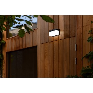 Schwarze, eckige Lutec LED Solar-Wandleuchte Fran mit Bewegungsmelder an Holzfassade.