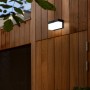 Schwarze, eckige Lutec LED Solar-Wandleuchte Fran mit Bewegungsmelder an Holzfassade.