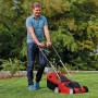 Einhell Elektro-Rasenmäher GC-EM 1032 im Einsatz: Roter Rasenmäher mit Bediener auf Rasenfläche.