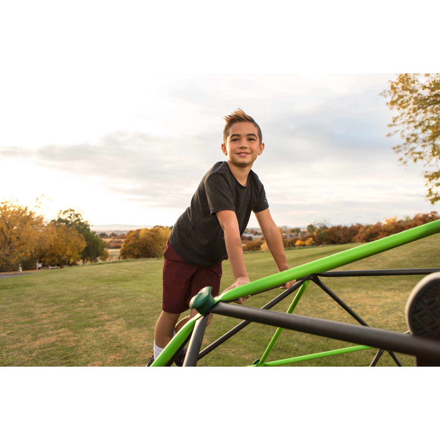 Junge klettert auf Lifetime Geodome Klettergerüst (335x168cm) im Garten.
