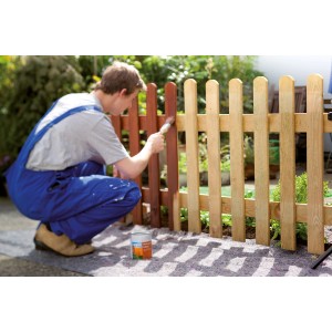 Mann streicht Zaun auf LUX Abdeckvlies 1x10m. Schutz vor Farbe & Schmutz beim Heimwerken.