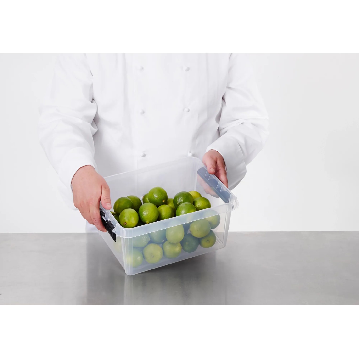 Transparente SmartStore Aufbewahrungsbox Classic 8 l mit Limetten, gehalten von einer Person.