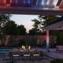 Philips Hue Festavia LED-Lichterkette (40m) in Schwarz, dekoriert eine Terrasse mit Pool und Esstisch.
