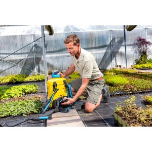 Mann bedient gelben Gloria Akku-Rückensprüher Pro 1200 li-on im Gewächshaus.