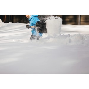 Person schaufelt Schnee mit der Fiskars Schneeschaufel Telescopic X-series.